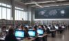 Diverse students work on laptops in a sunlit, modern university library as glowing icons of lightbulbs and gears float from their screens, symbolizing the spark of collaborative innovation in education.