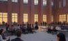 Students gathered in a courtyard at a modern university campus at dusk, blending traditional brick and glass architecture to symbolize the fusion of academic tradition and technological innovation in cybersecurity education.