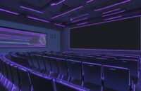 Diverse students in a modern lecture hall watch a glowing neural network architecture displayed on a large projection screen.