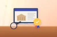 Laptop showing a university website, an accreditation seal with a check mark and a magnifying glass